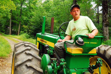 An adult man drives his tractor during a tour of his farm in Wilmington, Vermontのeditorial素材