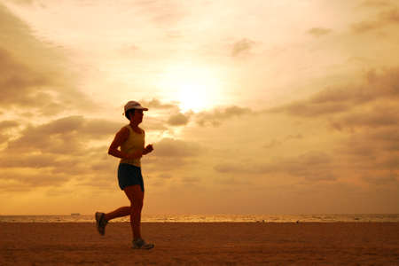 A jogger runs along the coast of Miami Beach at sunriseのeditorial素材