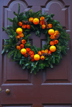A Christmas wreath of real fruit hangs from a door in Williamsburg, Virginiaの写真素材
