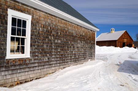 A shingled wooden barn and storage have stood through many harsh winters in New Hampshireの写真素材