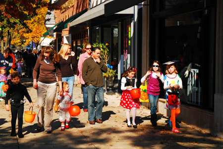 Trick or treaters walk through downtown Westfield New Jersey where local stores hand out the Halloween goodiesのeditorial素材