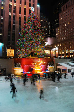 Ice Skaters glide underneath the famous Christmas tree in Rockefeller Center, New Yorkのeditorial素材