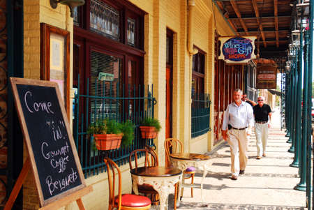 A group of men walk amongst the cafes of Pensacola, Floridaâs historic Seville Districtのeditorial素材