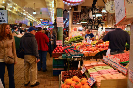 Customers shop for fresh fruit and vegetables at the stalls in the Pike Street Market in Seattleのeditorial素材