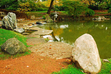 Autumn leaves surround a calm Japanese style gardenのeditorial素材