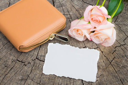 Wallet with flowers and paper on wooden background.の写真素材