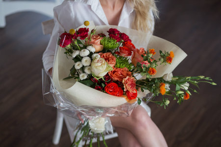 Bright and pretty bouquet of colorful, beautiful flowers in woman handsの写真素材
