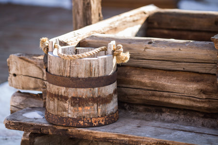 an old wooden bucket stands by the wellの写真素材