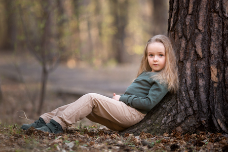 Girl is sitting under the tree in the parkの写真素材