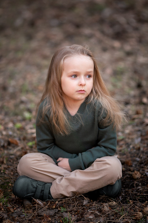 Girl is sitting under the tree in the parkの写真素材
