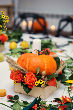 the bright autumn arrangement of flowers and berries in the pumpkinの写真素材