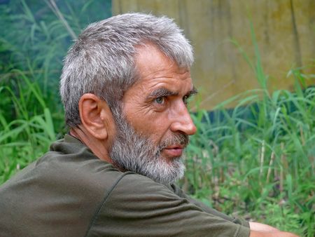 A portrait of the weather-burned man with grey beard and intent look. Profile. Russian Far East, Primorye.の写真素材