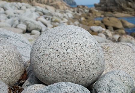 A close-up of stone granite ball on seacoast.の写真素材