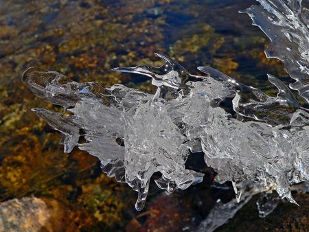 A close up of the fancy melting ice abobe the flowing water.