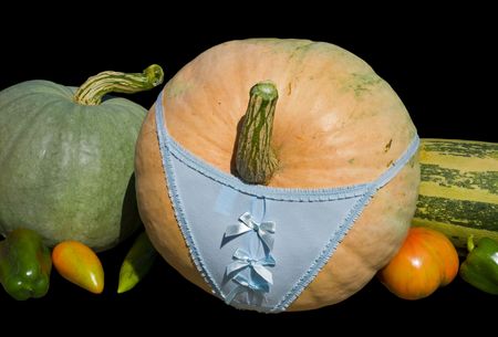 A close-up of the vegetables: big pumpkin in panties, vegetable marrow, tomato, pepper. Isolated on black.の写真素材