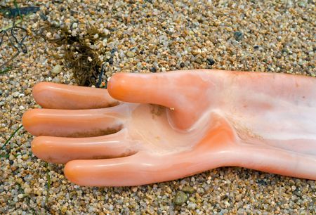 A close up of the old yellow glove on sand of beach.の写真素材