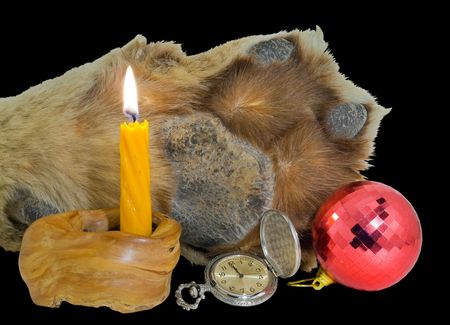 A close up of the paw of tiger, burning candle, watch and red sphere. Symbol of year 2010. Isolated on black.の写真素材