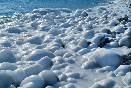 Winter on sea: stones with ice, seawater and surf.の写真素材