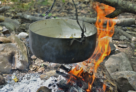 A cooking fish-soup in pot on bonfire.の写真素材