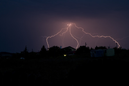 Lightning bolt striking in the sky from clouds