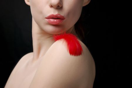 Young topless woman blowing a plumeの写真素材