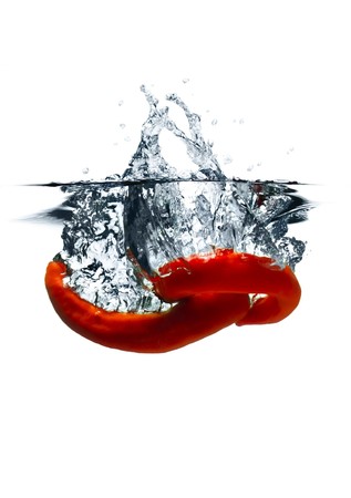 Red hot chili peppers dropped into water with splash isolated on whiteの写真素材