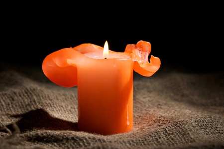 Closeup of a burning candle on the dark backgroundの写真素材