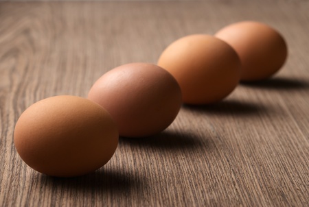 Brown eggs in a line on white backgroundの写真素材