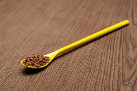 Teaspoon full of chocolate shavings, on a wooden background closeupの写真素材