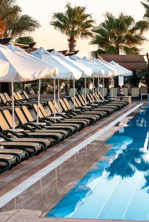Early morning outdoor pool with sunbeds and umbrellas in luxury resortの写真素材