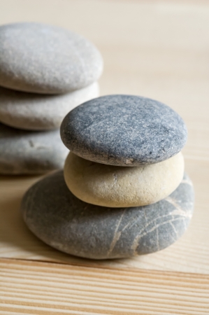Six spa zen stones stacked on a light wood backgroundの写真素材