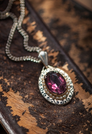 Vintage ruby pendant with chains on a wooden backgroundの写真素材
