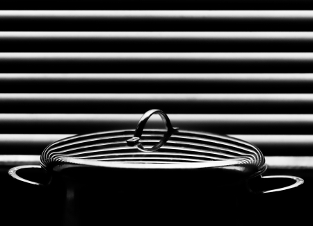 Shiny stainless saucepan with cover on the abstract background of blindsの写真素材