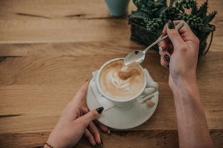 close up of a person holding a cup of coffee