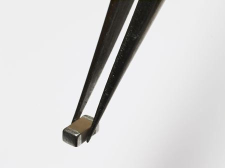 chip capacitor kept by a tweezers on a white background.の写真素材