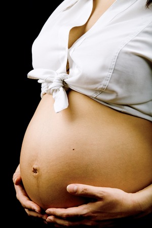A belly of pregnant woman isolated on black