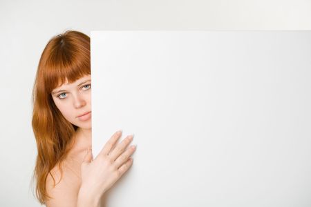 An attractive redhead girl with empty signの写真素材