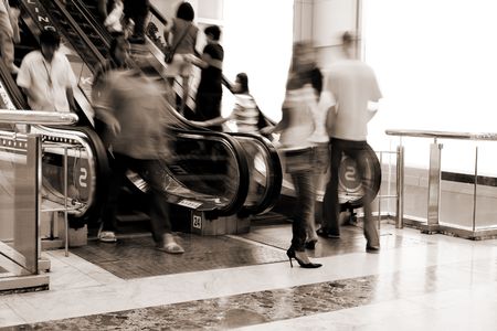 Abstract of people moving on escalator in the shopping mall(signs on escalator - bowling, karaoke)