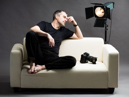 of tired grapher sitting on sofaの写真素材