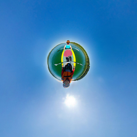man and woman in a kayak floating down the river. stereographic panorama little planetの写真素材