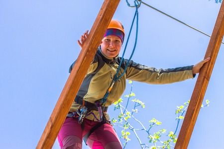 girl climbs into ropes course. Fearfully