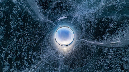 Blue ice of Lake Baikal covered with cracks, cloudy weather sunset.の写真素材