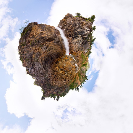 Man under a mountain waterfall in the form of a stone of heartの写真素材