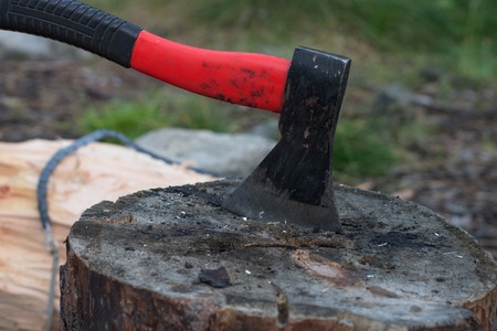 Axe in billets, chainsaw lying on logの写真素材
