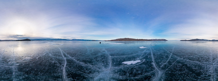 Blue ice of Lake Baikal covered with cracks, cloudy weather sunset.の写真素材