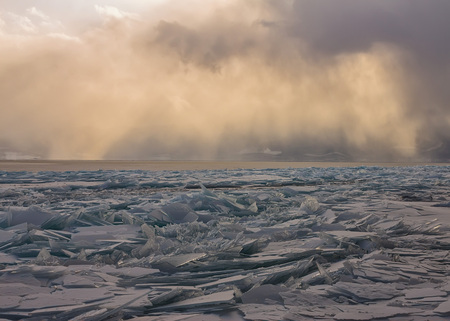 Transparent Baikal ice hummocks at sunset in the fog