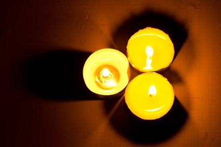 Small round candle burning in the dark tabletの写真素材