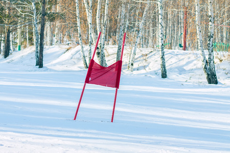 Slalom flag standing in the snow on the ski slopesの写真素材