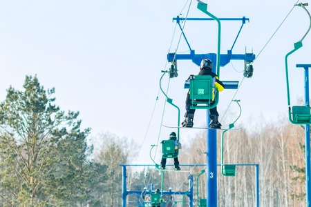 Snowboarder rises to the chairlift to the trackの写真素材