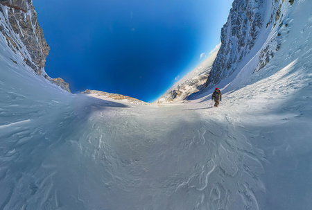 wide-angle view of a mountain hiker to climb a mountain of snow couloir.の写真素材